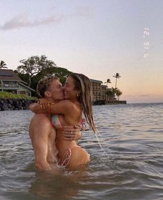 two people in the water kissing each other