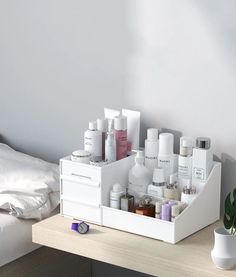 a white tray with bottles and other items on it next to a potted plant