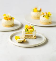 three small desserts on white plates with yellow and orange flowers in the top one