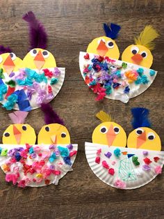 four paper plates decorated with birds and flowers on a wooden table, one is made out of construction paper