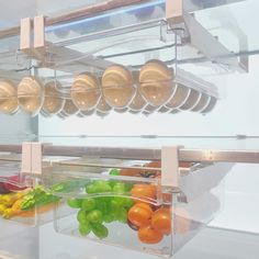 an assortment of fresh fruits and vegetables in a glass display case with hanging utensils