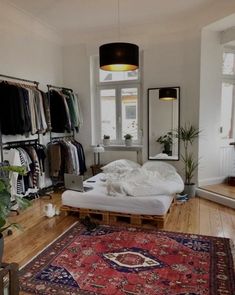 a bed sitting on top of a wooden floor next to a rug in a room