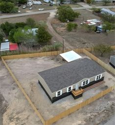 an aerial view of a house in the middle of a lot with lots of dirt