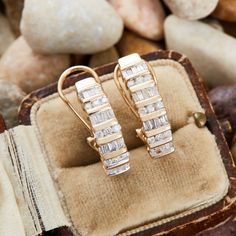 These gorgeous "J" hoop style pierced earrings are accented with eighteen (18), channel set, round brilliant cut diamonds and thirty-eight (38), channel set, baguette cut diamonds. The earrings measure 21.7mm X 5.8mm and are finished with hinged omega backs. The earrings have ever so slightly different curves so the backs do not line up exactly the same, but the earrings will appear the same when worn. Luxury Yellow Gold Hoop Earrings With Bail, Luxury Yellow Gold Channel Set Earrings, Luxury Gold Channel Set Diamond Earrings, J Hoop, J Style, Baguette Cut Diamond, Channel Set, Baguette Cut, Diamond Jewellery