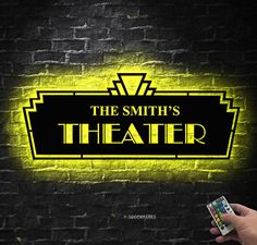 the smith's theater neon sign in front of a brick wall with a hand holding two cards