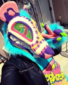 a person wearing a colorful animal mask on their head