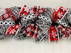 a red and black bow with white polka dots on the bottom is attached to a wall