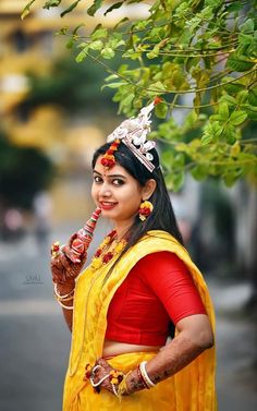 a woman dressed in yellow and red poses for the camera with her hand on her lip