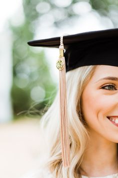 a woman wearing a graduation cap and gown smiling at the camera with her hand on her shoulder