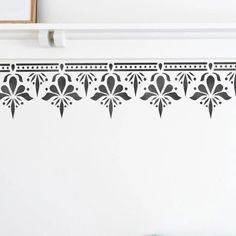 an ornate wall decal with black and white designs on the border, in front of a