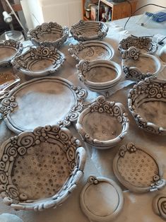 many plates are sitting on the table with holes in them, and they look like they have been made out of clay