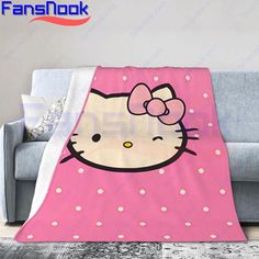 a pink blanket with a hello kitty face on the front and bottom, sitting on top of a couch