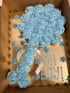 a box filled with blue cupcakes sitting on top of a table