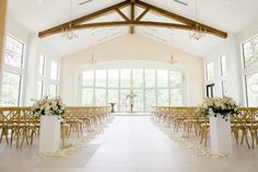 an indoor wedding venue with white flowers and gold chairs