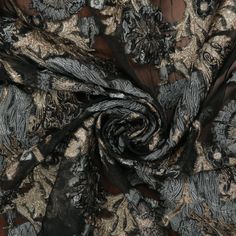 an image of a black and gold fabric with floral designs on it's side