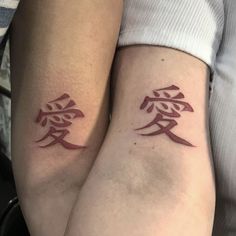 two people with matching tattoos on their arms, one is holding the other's arm