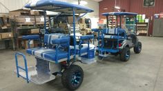 two blue and silver golf carts in a warehouse