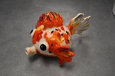 an orange and white fish figurine sitting on top of a table