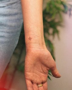 a woman's hand with a tiny star tattoo on her left wrist and finger