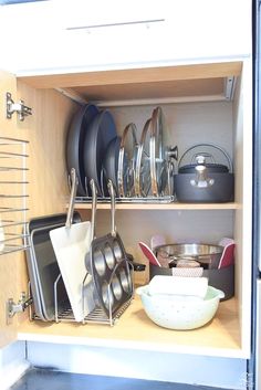 an open cabinet filled with pots and pans