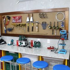 several blue stools sit in front of a workbench with tools on it