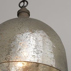 an old metal light hanging from a chain