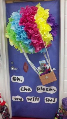 a door decorated with colorful paper flowers and saying, oh the places we will go