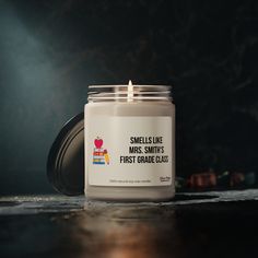 a candle that is sitting on a table with an apple label in front of it