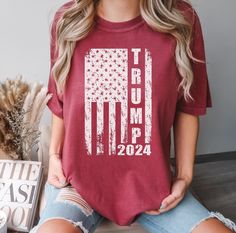 Show your patriotic spirit with our Comfort Colors T-Shirt featuring a grunge American flag graphic and the words "Trump 2024."  Made from high-quality, ultra-soft cotton, this unisex tee offers a relaxed fit that's perfect for casual wear. The vintage-style design adds a touch of retro charm.  Key Features: Comfort Colors Brand: Known for its durability and comfort. Material: 100% ring-spun cotton for a soft, breathable feel. Fit: Unisex sizing, relaxed fit - ideal for both men and women. Style: Vintage-inspired, perfect for patriotic events or everyday wear. Colors: Black, Denim, Pepper, Denim,Moss, Light Green, Yam Sizes: Small to 4XL - find your perfect fit. Why You'll Love It: High-Quality Fabric: Soft, pre-shrunk, and garment-dyed for a lived-in feel from the first wear. Versatile St Pop Design, Mode Vintage, Vintage Stil, Tshirt Colors, Comfort Colors, Style Vintage, American Flag, Quality Fabric, Vintage Style