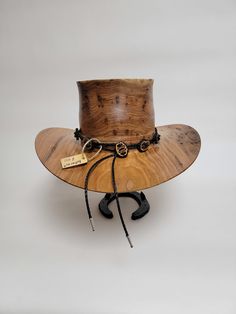 Beautiful wood-turned hat made from Butternut. Make a fashion statement in this unique hat! Measurements: Inside circumference: 23 inches Bill: 16" x 14" Height: 8" Weight: 3 lbs. ﻿Hatband and stand available for purchase separately. Unique Adjustable High Crown Costume Hat, Luxury Western Wool Top Hat, Fitted Brown Western Top Hat, Luxury Handmade Western Top Hat, Handmade Western Brown Top Hat, Luxury Brown Fur Felt Cowboy Hat, Unique Hats, Cowboy Hat, Hat Band