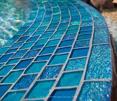 a blue mosaic tile next to a swimming pool