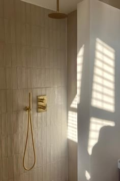 a bathroom with a shower head, toilet and bathtub next to a wall mounted faucet