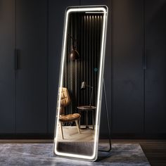 a large mirror sitting on top of a wooden floor next to a chair and table