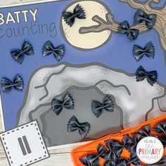 an orange tray filled with black bows next to a blue and white paper cutout