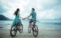 a man and woman riding on the back of bikes near the ocean with text that reads tecomparo com