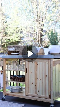 a kitchen island on wheels with bowls, plates and utensils