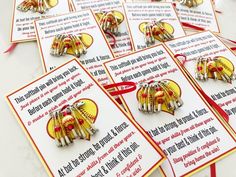 some red and yellow brooches are sitting on a table with cards attached to them