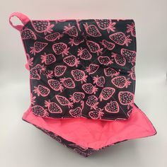 two pieces of black and pink fabric with pomegranates on them, one in the shape of a bag