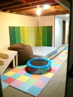 there is a room with two beds and a play mat on the floor in front of it