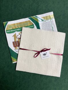 an envelope tied up with a red ribbon on top of two other mail bags, both wrapped in white paper