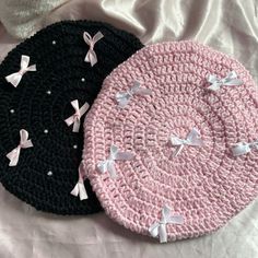 two crocheted hats with bows on them