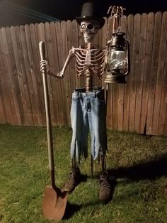 a skeleton is holding a shovel and standing in the grass