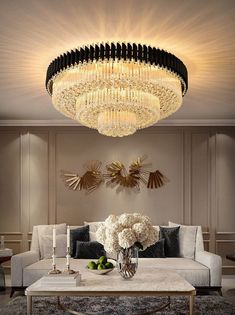 a living room filled with furniture and a chandelier hanging from the ceiling above it