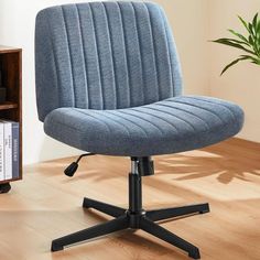 a blue office chair sitting on top of a wooden floor next to a book shelf