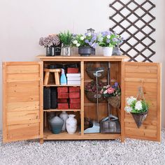 a wooden cabinet filled with lots of flowers and gardening implements on top of it's sides