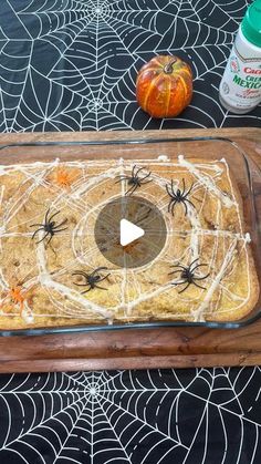 a spider web cake on a table with pumpkins and spooky yarn around it