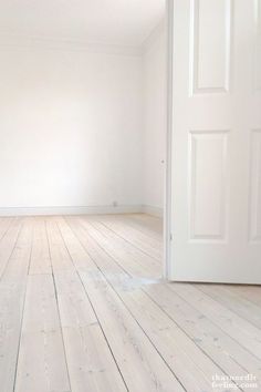 an empty room with white walls and wooden floors