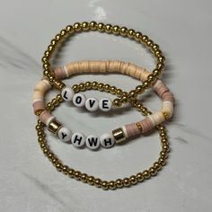 3pc stackable bracelets. YHWH and LOVE. Pale pink beads and gold beads. Casual Gold Heishi Beads Jewelry, Casual Gold Beaded Charm Bracelet, Trendy Gold Beaded Bracelets With Heishi Beads, Casual Gold Heishi Beads Stretch Bracelet, Everyday Gold Name Bracelet With Colorful Beads, Pink Charm Bracelet With Letter Beads For Everyday, Pink Letter Beads Charm Bracelet For Everyday, Personalized Gold Heishi Beads Bracelets, Gold Heishi Beads Bracelet With Letter Beads