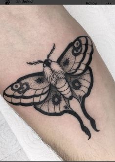 a black and white butterfly tattoo on the leg