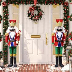 two christmas nutcrackers standing in front of a door decorated for the holidays